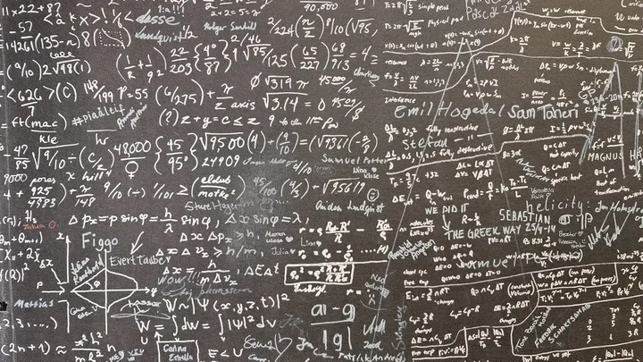 A chalkboard covered in handwritten mathematical equations