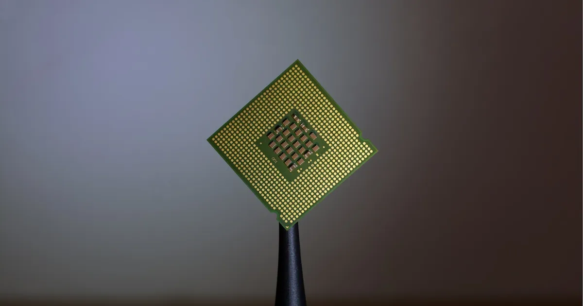 A close-up of a computer chip held between two fingers