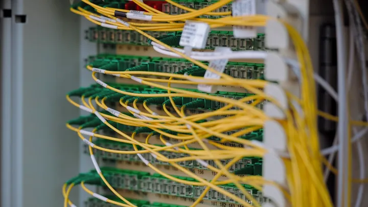 A dense bundle of network cables running through a data center hall
