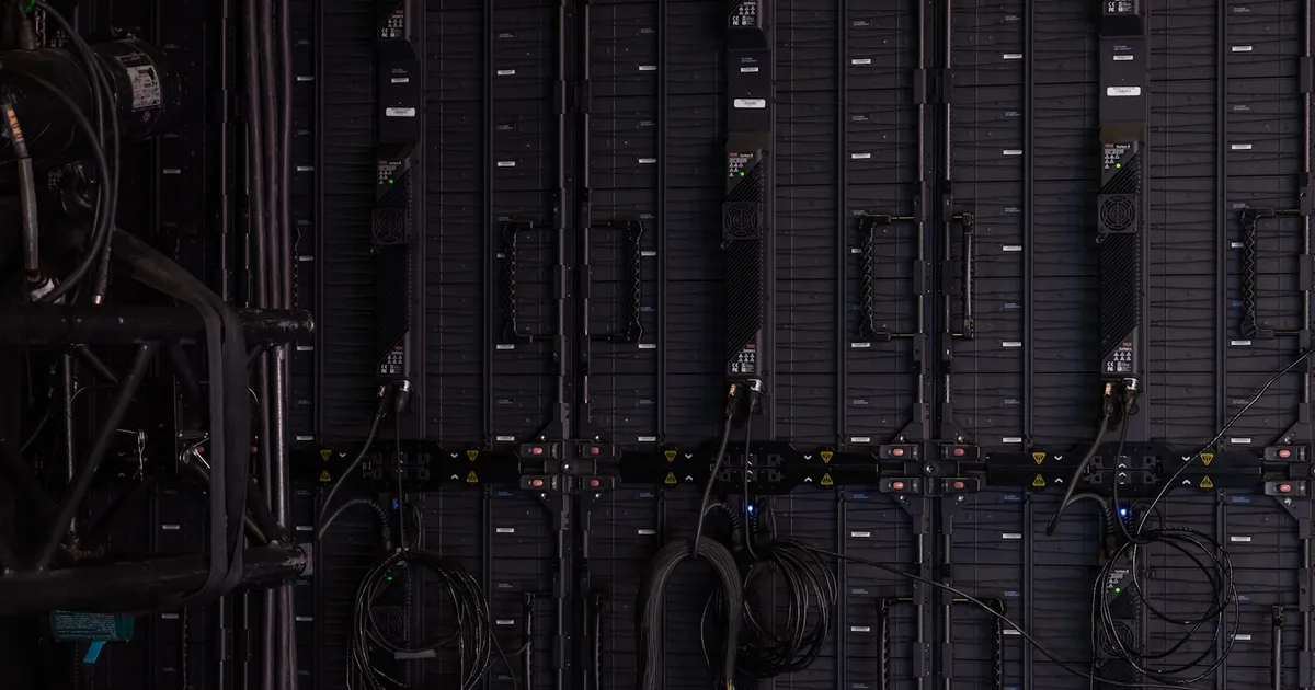 Rows of illuminated server racks stretching down a data center aisle