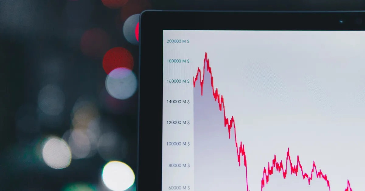 A declining stock price chart trending downward in red