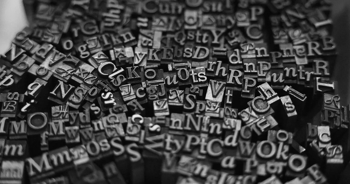 Rows of metal letterpress type arranged in a printer's tray