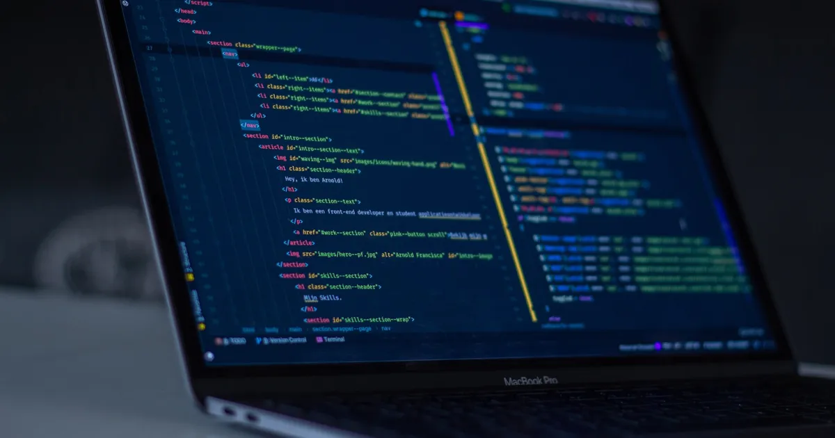 Code on a laptop screen in a dark room