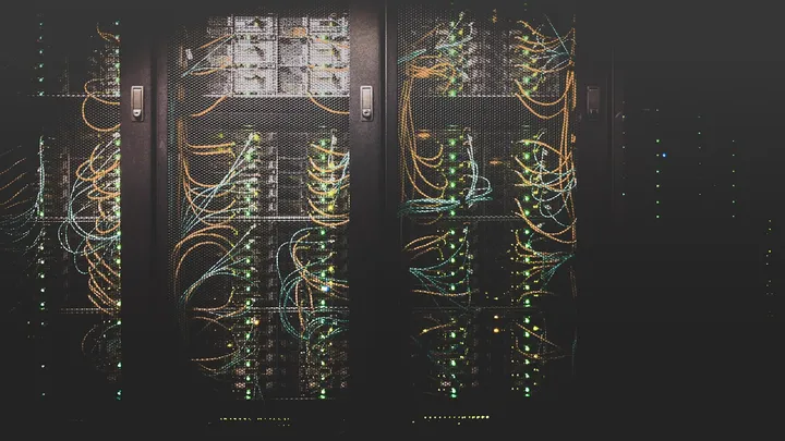 Rows of server racks with dense bundles of network cabling in a data center