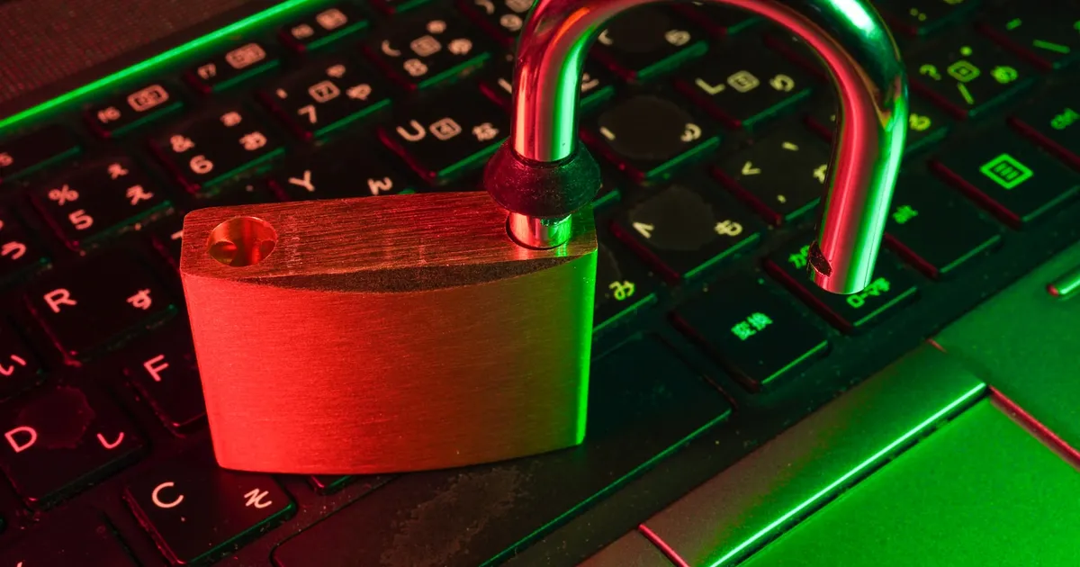 An open padlock resting on a laptop keyboard